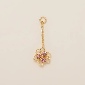 Detalle del colgante casa hongo de oro 18K con gemas rosas y diseño floral calado