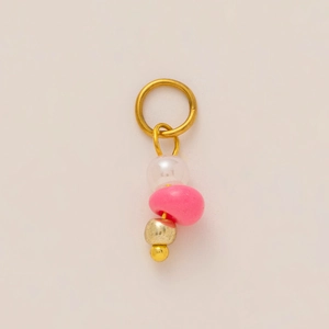 Close-up of golden ring pendant with white, pink, and gold beads on white background