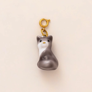 Détail d'un pendentif chat gris et blanc avec un fermoir à ressort en métal doré