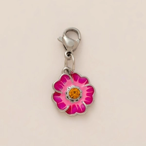 Detailed macro view of an 18K gold plated flower pendant with enamel and central gemstone