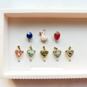 Pastel enamel pendants featuring ducks and flowers in a vintage gold finish tray
