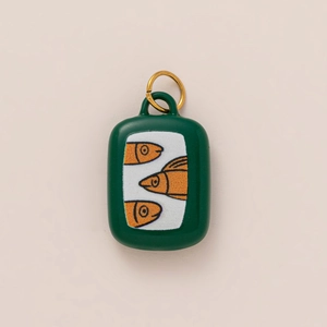 Detail eines Sardinendose-Taschenanhängers in Dunkelgrün mit goldenem Ring und Fisch-Motiv