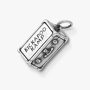 Détail macro d'un pendentif valise argenté vintage avec gravure Kickapoo Kamp