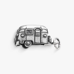 Détail macro du pendentif caravane rétro en finition vintage avec porte et fenêtre ciselées