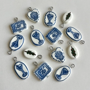 Handcrafted ceramic pendant charms featuring colorful blue hand-painted fruit and sea life designs