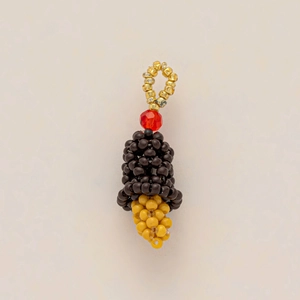 Close-up of handmade beaded zodiac snake pendant with red crystal and golden ring