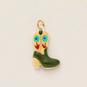 Detailed view of a vintage style cowboy boot pendant with floral patterns and gold ring
