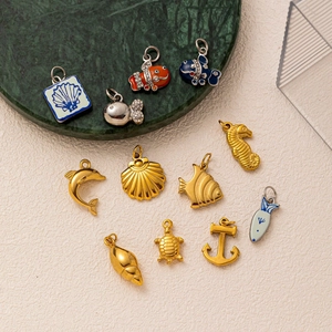 Marine life pendants set in 18K gold stainless steel including turtle, shell and dolphin