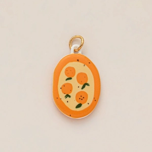 Detailed view of orange citrus pattern on oval enamel pendant with golden jump ring