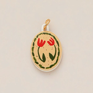 Detailed close-up of oval enamel pendant featuring red tulip flowers and a gold bail clasp
