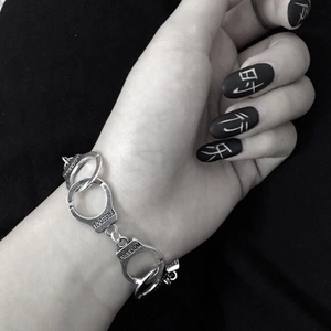 Silver metal handcuff bracelet with Freedom engraving shown on hand in punk style