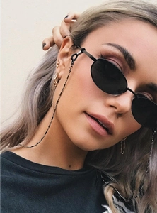 Détail des lunettes de soleil rétro noires avec chaîne de lunettes en métal doré