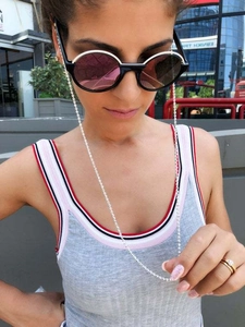 Close-up of a silver beaded eyewear chain paired with vintage round sunglasses