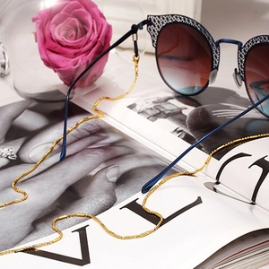 Chaîne de lunettes dorée tendance avec lunettes de soleil dégradées sur un magazine