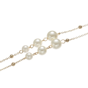 Macro detail of elegant double-layered gold chain with white pearls and small gold beads