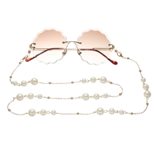 Detail of rimless gradient sunglasses with gold metal frames and pearl lanyard chain