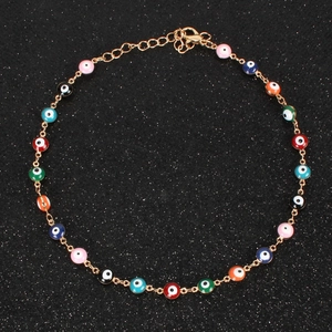 Detailed macro view of colorful evil eye beads on a golden adjustable link chain necklace