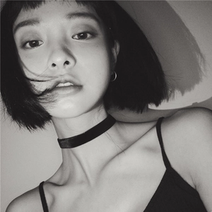 Close-up of minimalist black velvet choker and silver hoop earrings on a fashion model
