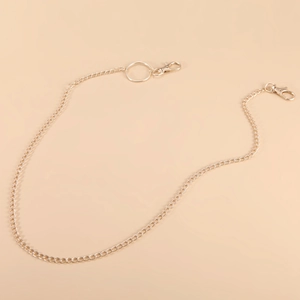 Detail of multi-layered gold metal waist chain featuring round ring and lobster clasps
