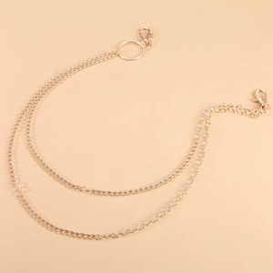 Close-up of dual-layer golden metal waist chain with lobster clasps and polished finish