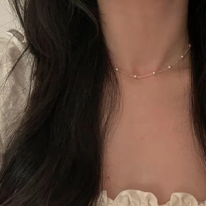 Close-up of a minimalist pearl bead choker necklace on model's neck for elegant style