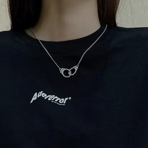 Close-up of vintage handcuffs pendant necklace in silver metal on model