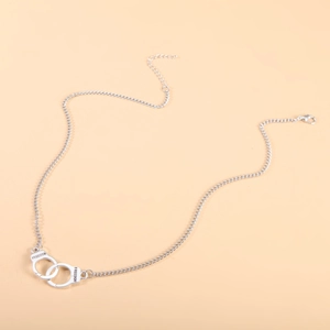 Detailed close-up of silver handcuff necklace with engraved Freedom text and lobster clasp