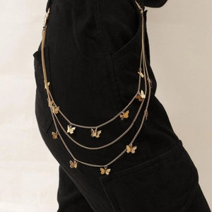 Detail view of golden multi-layer waist chain featuring metal butterfly pendants
