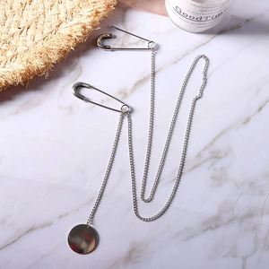 Silver metal chain brooch with double safety pins and a round pendant in punk style