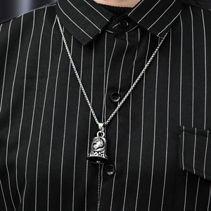Detailed view of vintage stainless steel eagle bell pendant on a silver chain