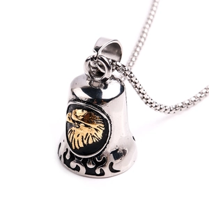 Macro view of eagle bell pendant with golden eagle relief and stainless steel chain