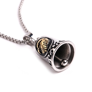 Macro view of vintage stainless steel eagle bell pendant with intricate side carvings