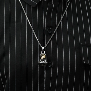 Detail view of retro eagle head bell pendant with floral carving on striped background