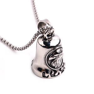 Macro shot of silver eagle bell pendant with detailed engravings on steel box chain