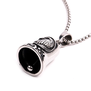 Detailed view of vintage silver eagle bell pendant with intricate feather engravings