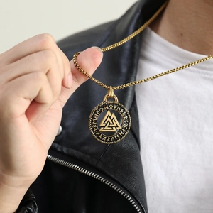 Λεπτομέρεια χρυσού μενταγιόν Valknut με χάραξη ρούνων και οδοντωτές άκρες