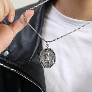 Details des religiösen Relief-Anhängers an einer Box-Kette mit schwarzer Lederjacke