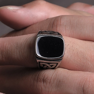 Vista macro dell'anello a sigillo da uomo con smalto nero e incisioni di nodi celtici