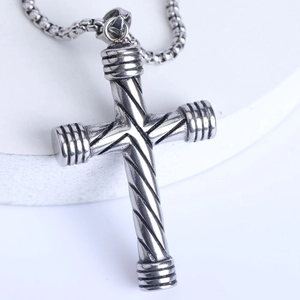 Vue macro du pendentif croix en acier inoxydable punk avec textures en spirale