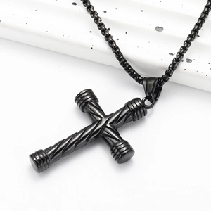 Détail macro du pendentif croix noire en acier inoxydable avec texture torsadée industrielle
