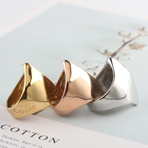 Drei stapelbare geometrische Stahlringe in Gold, Roségold und Silber auf einem Magazin