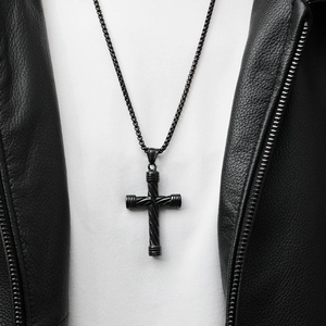 Détail d'un pendentif croix noire en acier pour homme avec chaîne box style punk