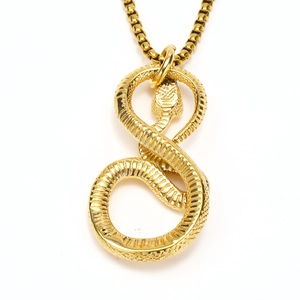 Macro detail of golden cobra pendant with textured scales and box chain necklace