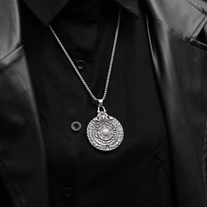 Vintage silver Aztec calendar pendant on square pearl chain worn over black leather jacket