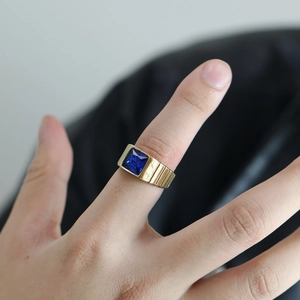 Vue détaillée d'une pierre saphir bleue carrée sertie dans une bague en titane plaqué or
