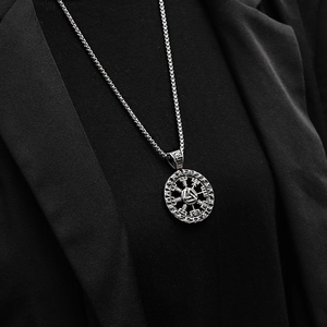 Close-up of Norse Viking Vegvisir pendant necklace on male model wearing black suit jacket