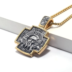 Detail van het Jezus-reliëf op een tweekleurige kruisbedel met gouden ketting