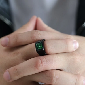 Détail macro d'une bague vintage noire pour homme avec une grande pierre verte carrée