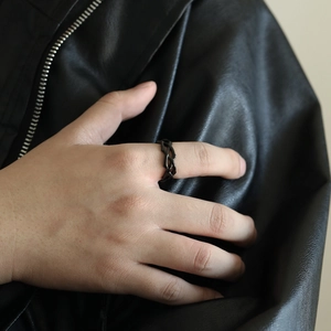 Detail of a black woven crossover ring made of titanium steel for a punk aesthetic