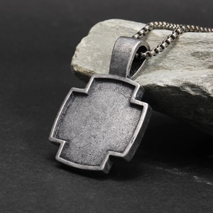 Macro-opname van vintage kruishanger met antieke afwerking en stalen Venetiaanse ketting